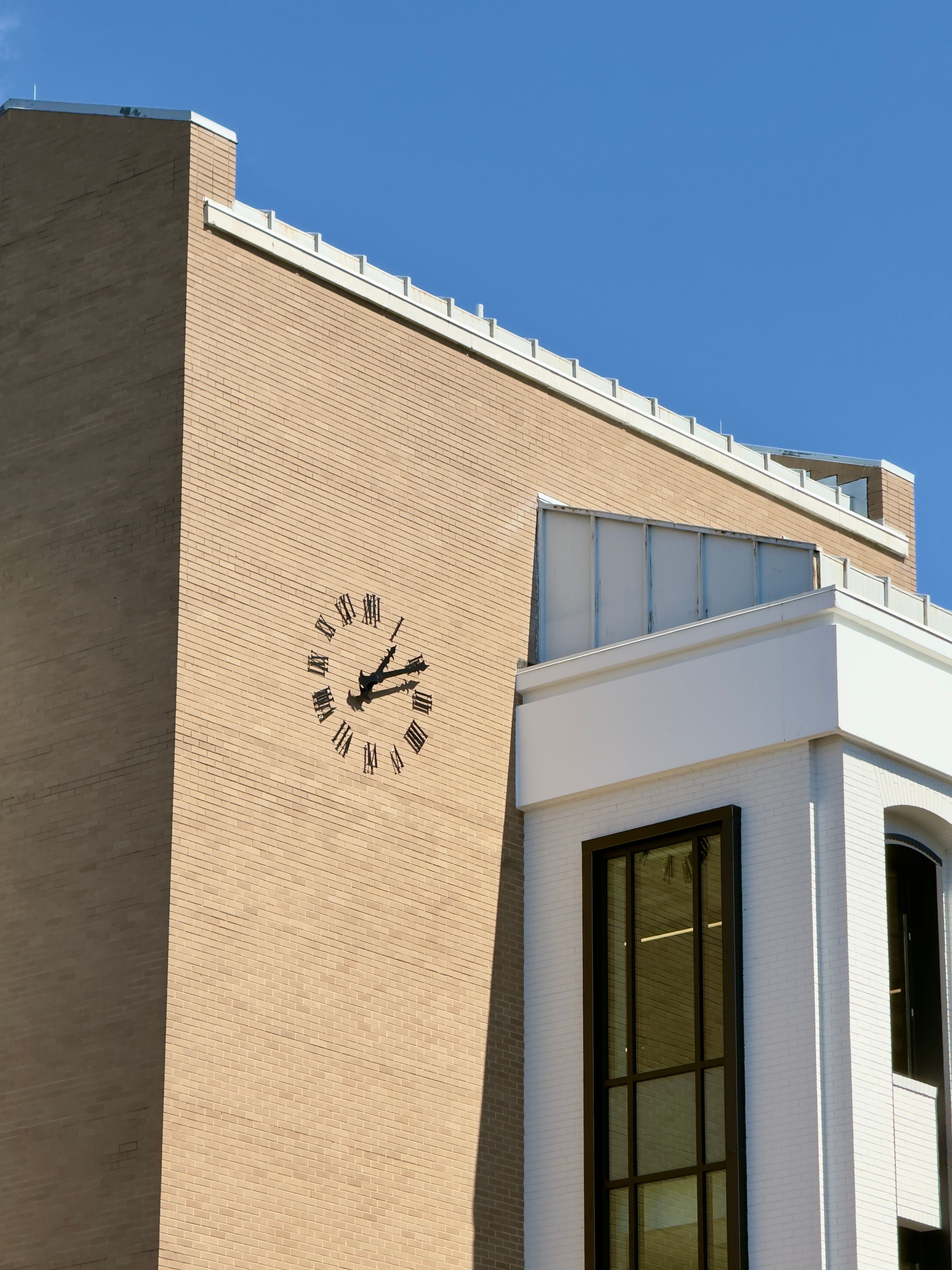 Modern Clock Tower with Brick Facade Against Blue Sky · Free Stock Photo