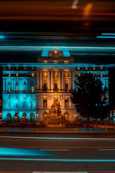 Night view of a neoclassical building in Buenos Aires with dynamic light trails enhancing the city's vibrant atmosphere.