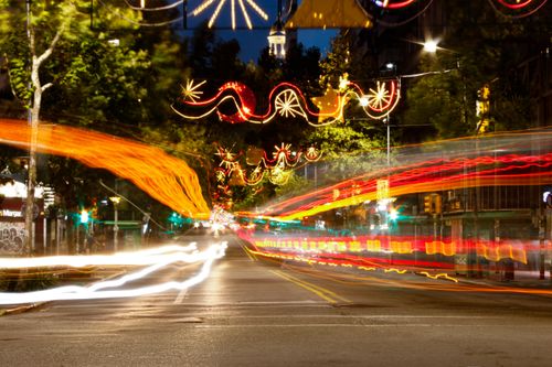 Free Dynamic city street scene captured at night, showcasing vibrant light trails and festive decorations. Stock Photo