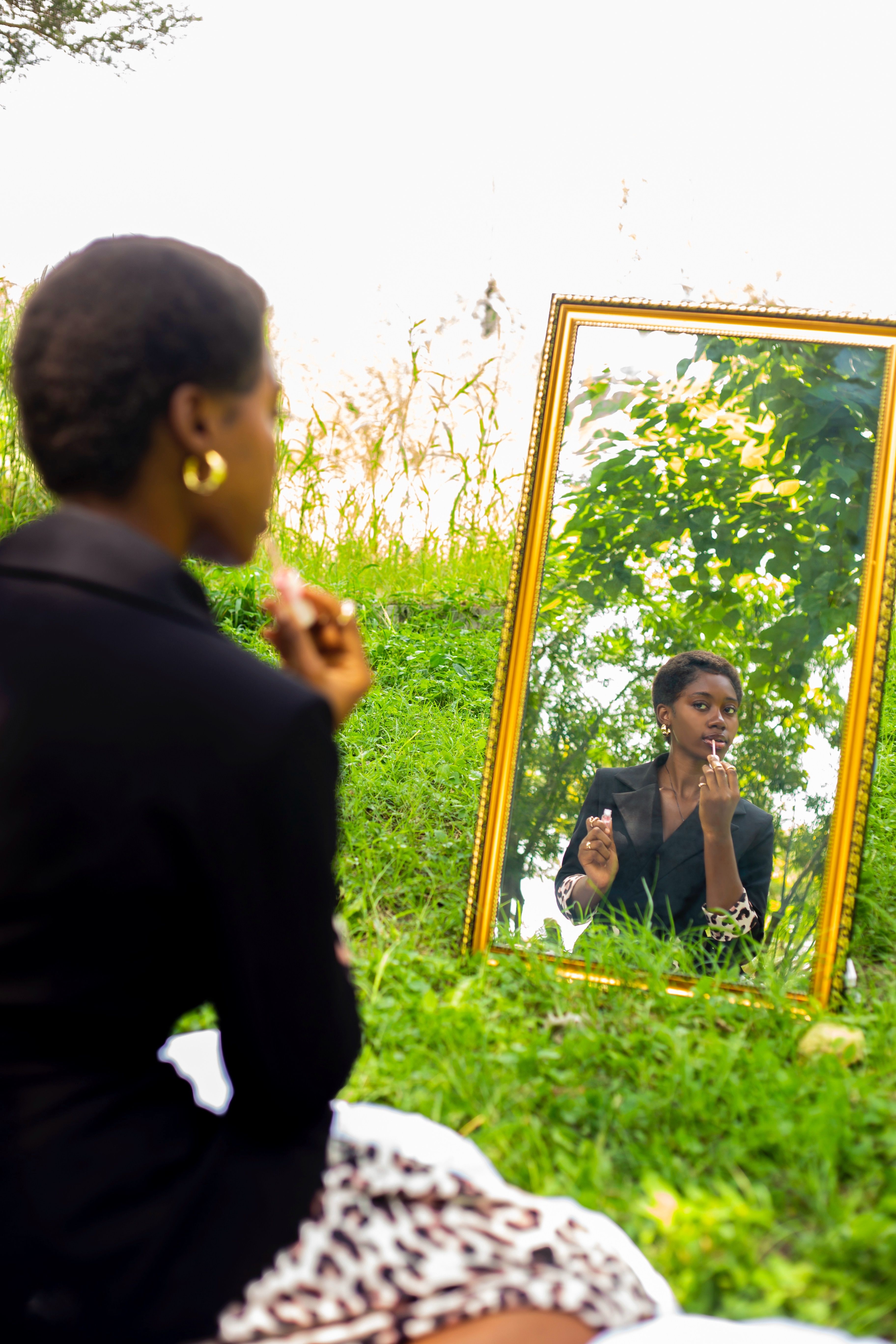 Woman Applying Makeup in Outdoor Mirror Reflection · Free Stock Photo