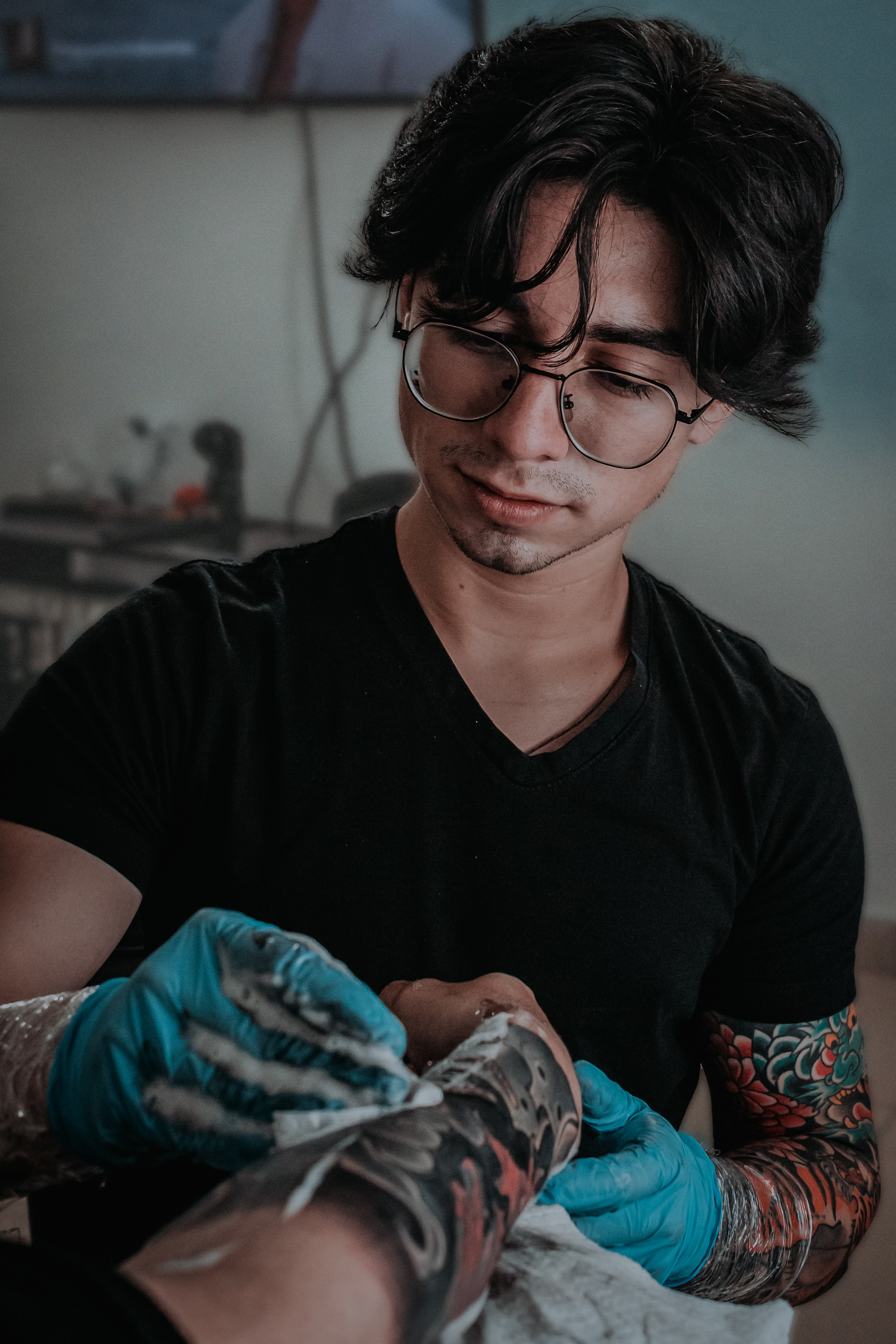 Talented tattoo artist working on detailed arm tattoos in a Bogotá studio.