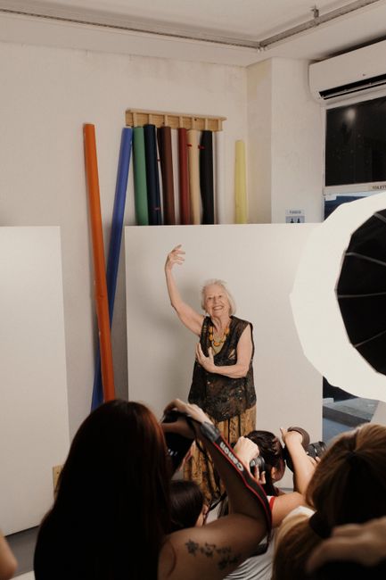 Elderly woman confidently posing for a photoshoot in a professional studio setting.
