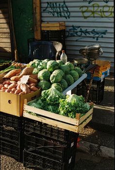 Vibrant display of fresh cabbages, potatoes, and greens at an outdoor market in Croatia.