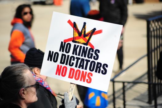 Protesters in Baltimore hold signs against dictatorial rule during a demonstration.