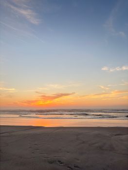 Captivating beach sunset with a golden sky and tranquil waves, ideal for relaxation themes.