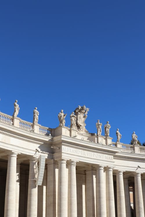 Free View of the colonnade at St. Peter's Basilica, Vatican City, with clear blue sky. Stock Photo