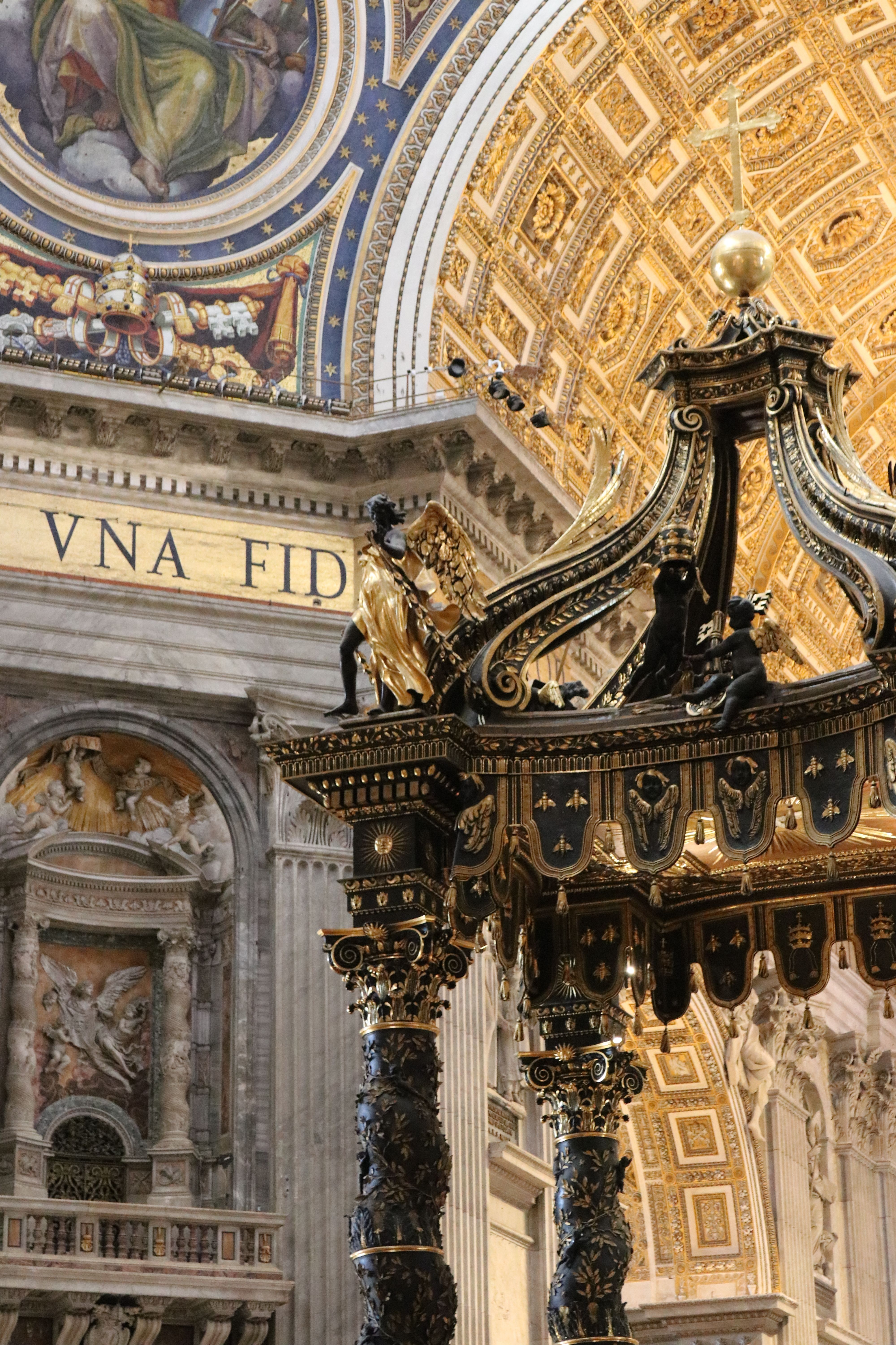 Stunning view of the ornate Baroque interior of St. Peter's Basilica in Vatican City, highlighting intricate gold and black details.