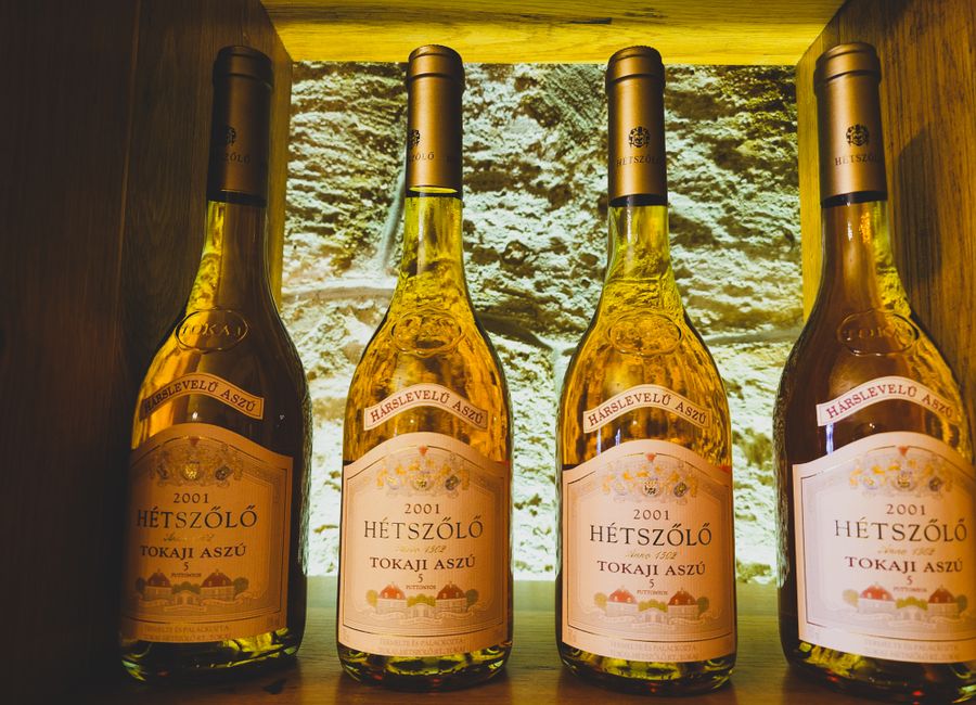 Four bottles of 2001 Hetszolo Tokaji Aszu wine in a cellar display.