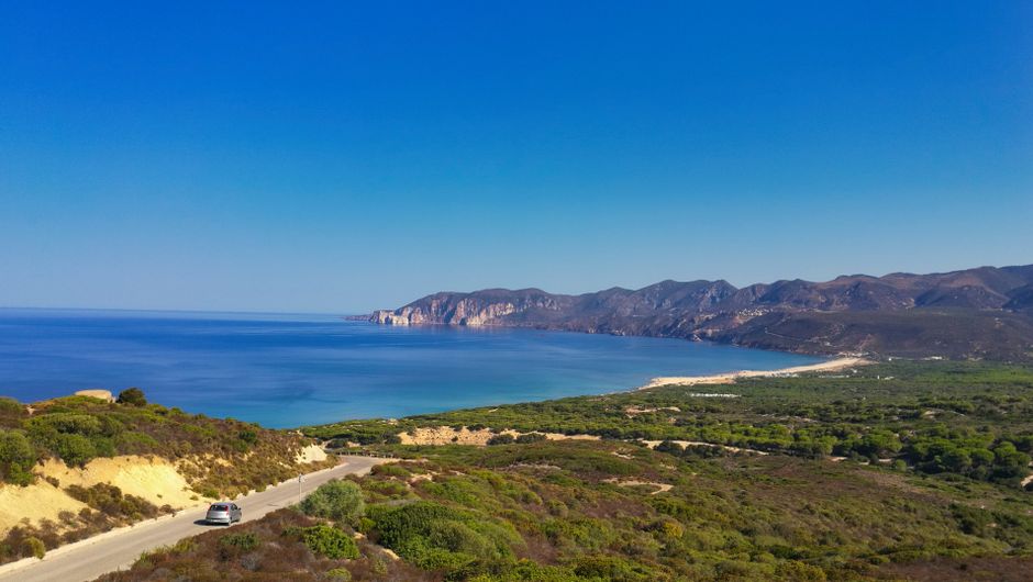 Beautiful panoramic view of the Sardinian coastline with clear blue waters and lush greenery.