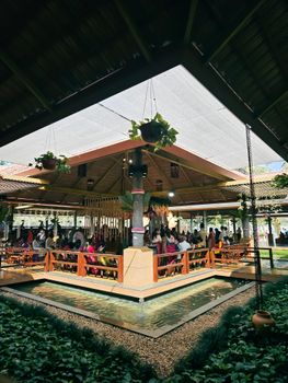 Vibrant gathering in a beautiful outdoor pavilion with lush greenery in Bengaluru.