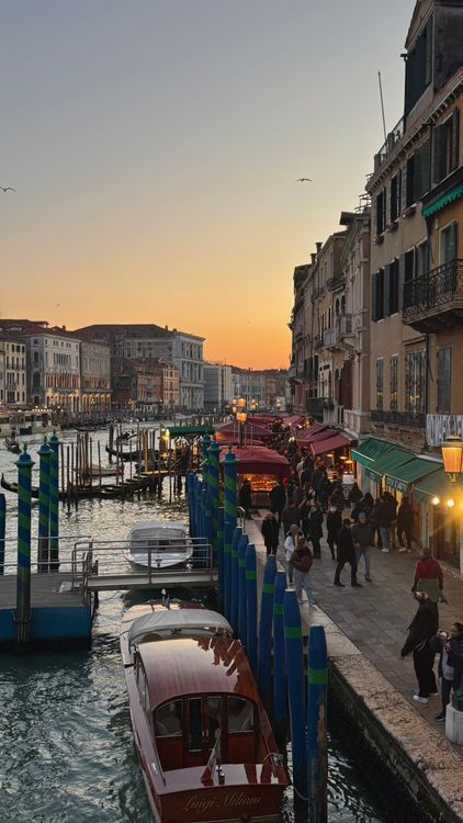 Free Explore the vibrant scene of Venice's Grand Canal at sunset, capturing the city’s bustling waterside life. Stock Photo