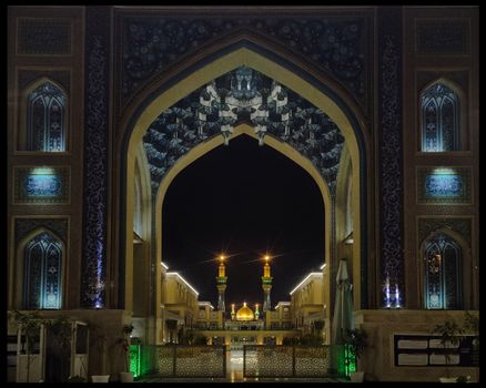 Nighttime view of an illuminated mosque arch with intricate designs.