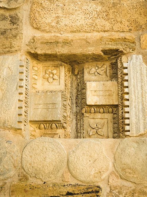 Free Close-up view of detailed stone carvings on an ancient wall showcasing floral and geometric patterns. Stock Photo