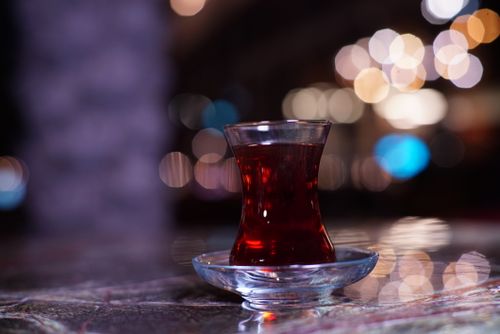 Free A close-up of traditional Turkish tea in a tulip-shaped glass with bokeh lights in the background. Stock Photo