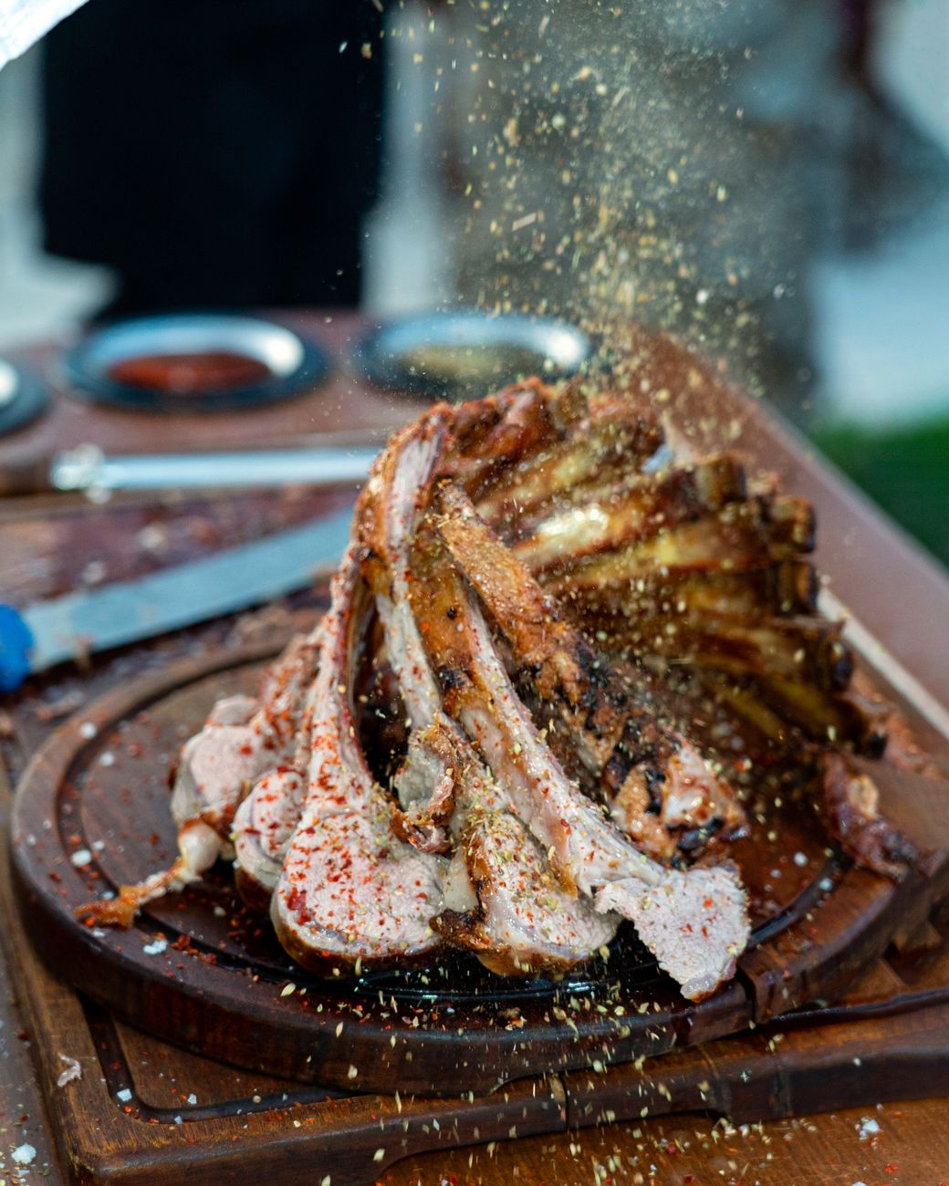 Moroccan mechoui lamb with dark spice rub and chile seasoning served on traditional clay plate