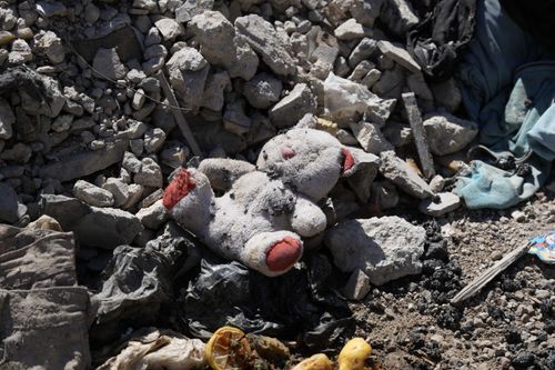 Free A worn teddy bear lies amidst rubble and debris in a deserted area of Damascus, Syria. Stock Photo