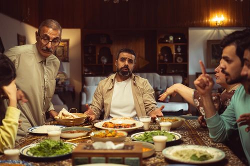 Free A family enjoys a lively meal around a dining table in a cozy home setting. Stock Photo