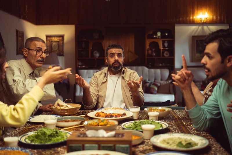 A family engaging in conversation over a traditional meal, fostering connection.
