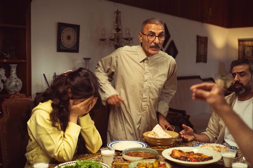 Free A family gathered around a dining table having an intense emotional exchange. Stock Photo