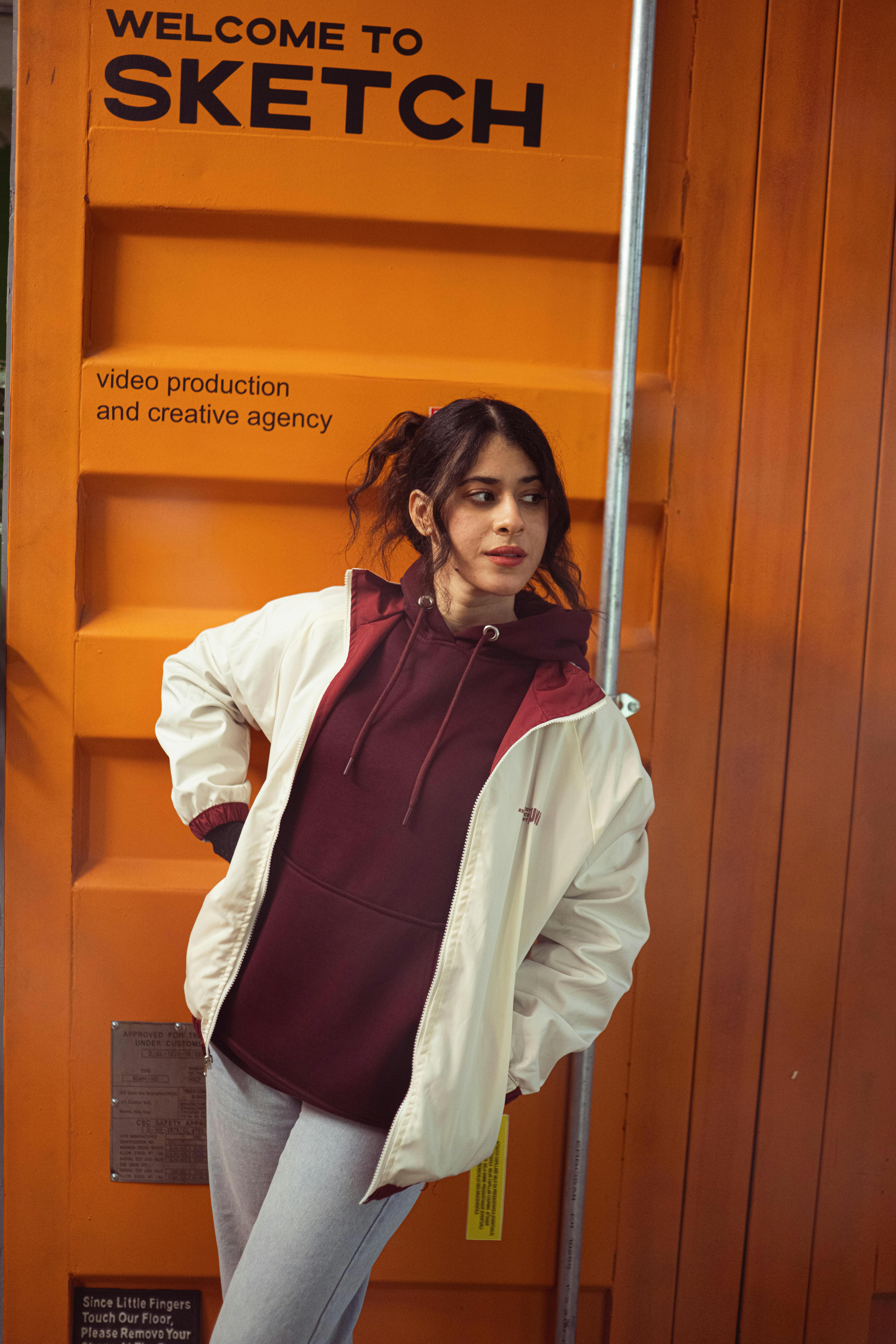 A woman poses stylishly in front of a creative agency's entrance.