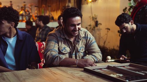 Free Group of friends enjoy a board game indoors with a warm and joyful atmosphere. Stock Photo