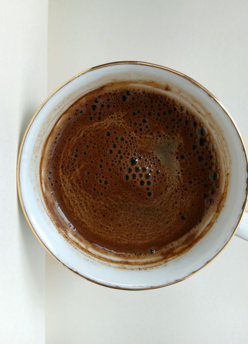 Free Aerial shot of freshly brewed espresso in a white cup on a light background. Stock Photo