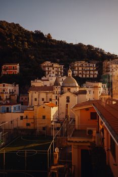 Charming Italian village featuring historic architecture and a serene landscape at sunset.