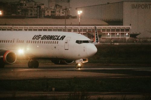 Free US-Bangla aircraft on airport runway during evening hours, ready for flight. Stock Photo