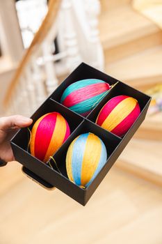 Vibrant striped Easter eggs neatly arranged in a gift box, perfect for seasonal celebrations.
