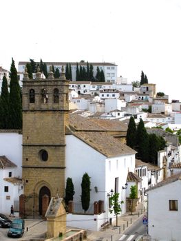 Charming view of traditional whitewashed buildings and church in Ronda, Andalusia, Spain.