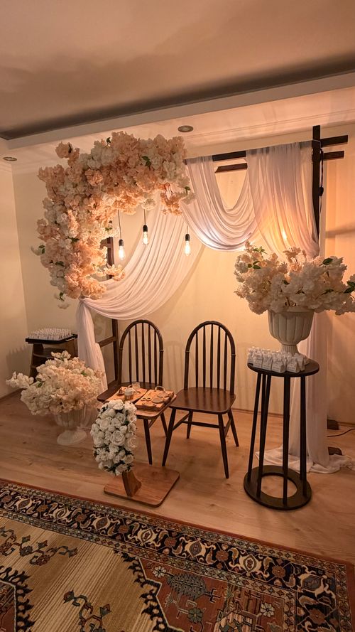 Free Beautiful indoor wedding ceremony setup with floral arch and chairs, featuring warm lighting. Stock Photo