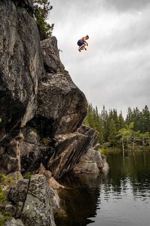 Man in Blue shorts jumping in a body of water