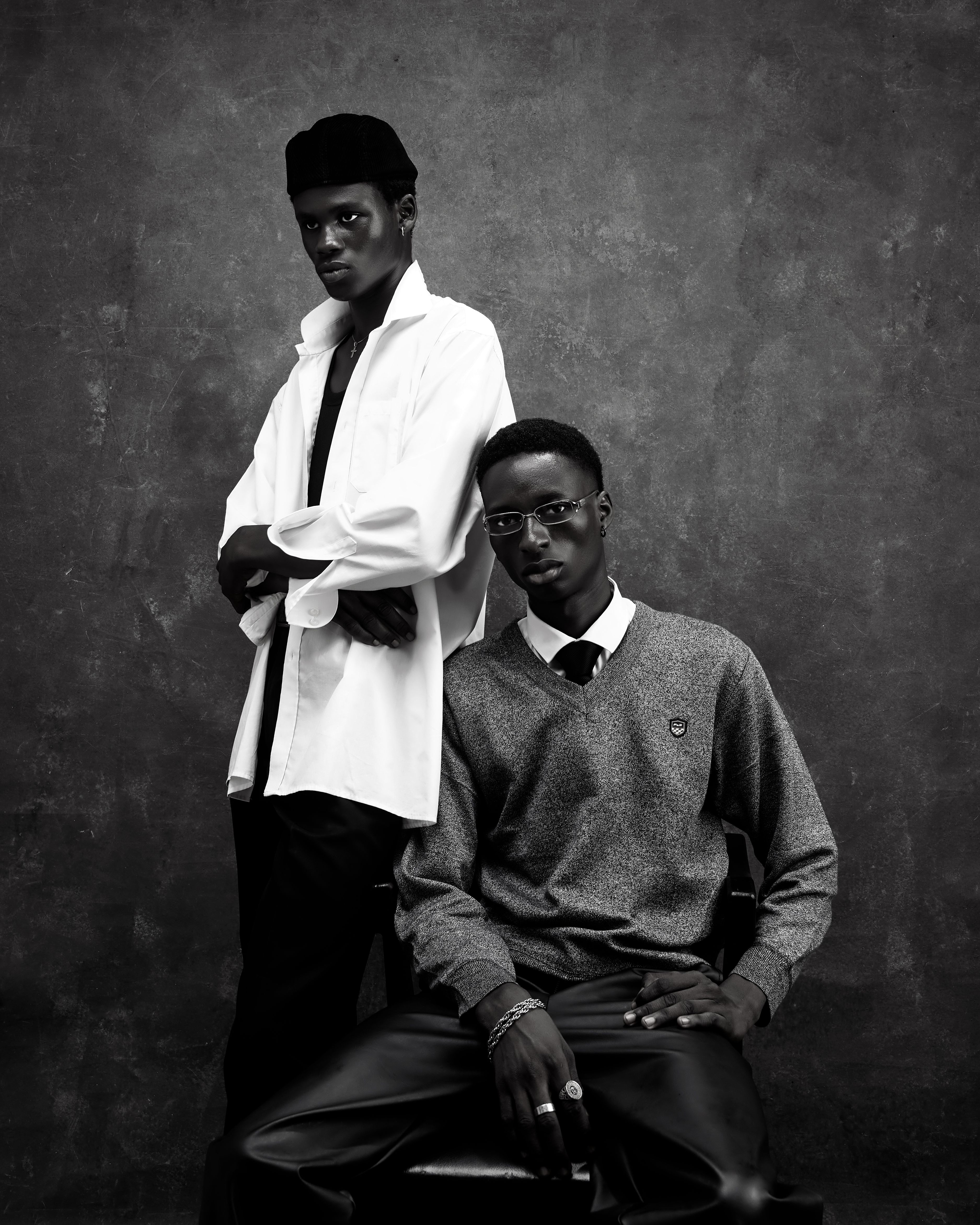 Elegant black and white portrait of two fashionable men in stylish attire.