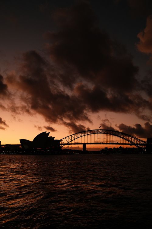 Free Stunning twilight view of Sydney Opera House and Harbour Bridge over darkened waters. Stock Photo