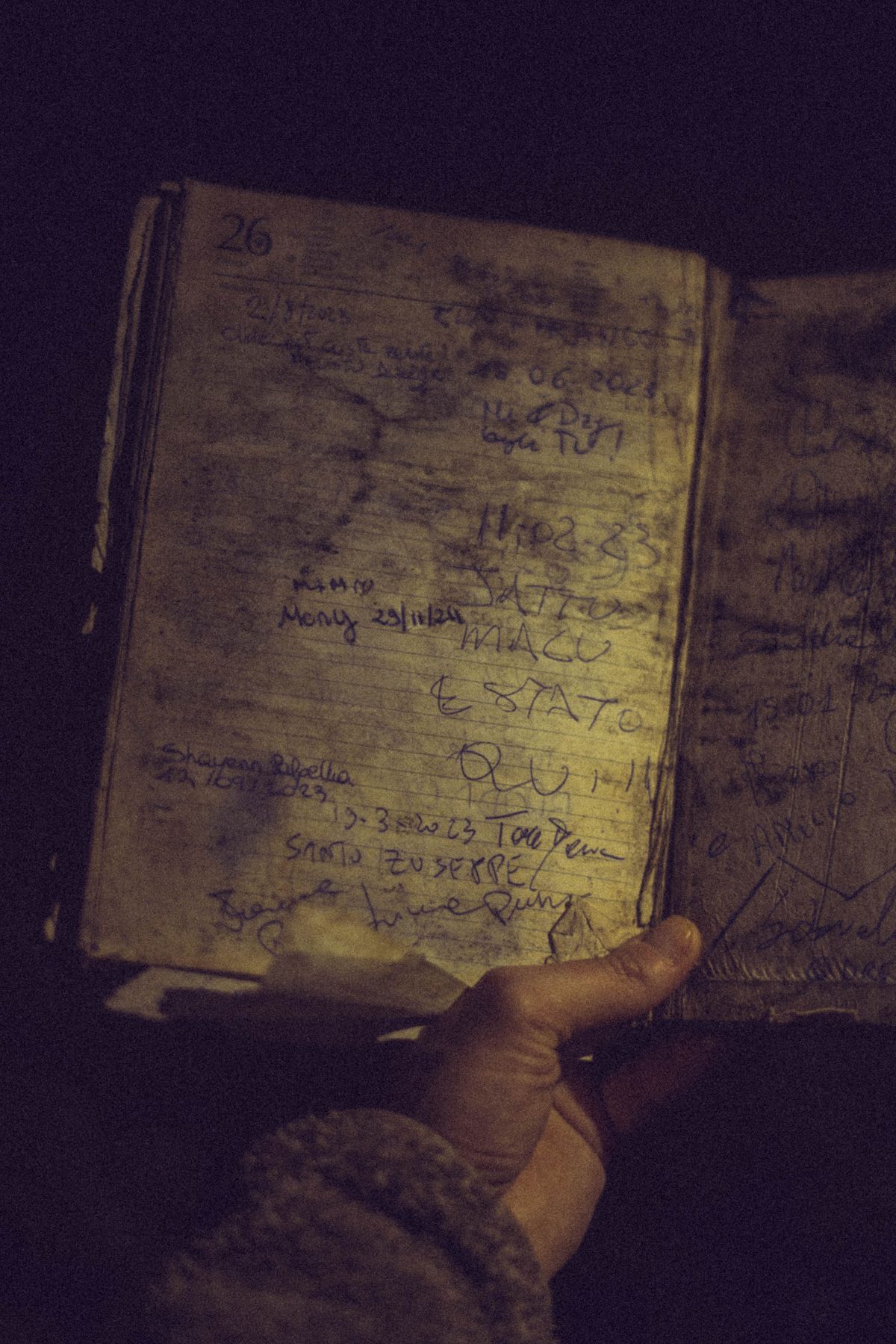 Manos sosteniendo un cuaderno antiguo en la penumbra
