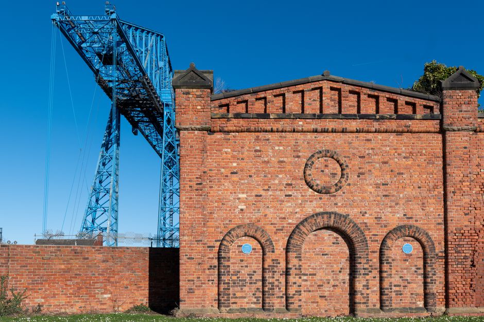 Historic Transporter Bridge and brick building in Middlesbrough, England, showcasing industrial heritage.