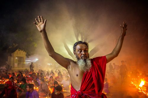 Free A powerful spiritual ceremony with an ascetic figure leading a gathering at night, surrounded by candles and smoke. Stock Photo