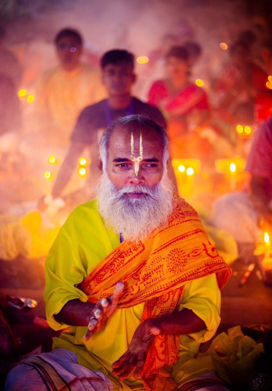 Pandit conducting a sacred ceremony by candlelight