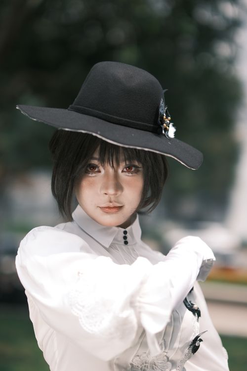 Free A fashionable individual with an elegant black hat poses outdoors, exuding a modern and artistic vibe. Stock Photo