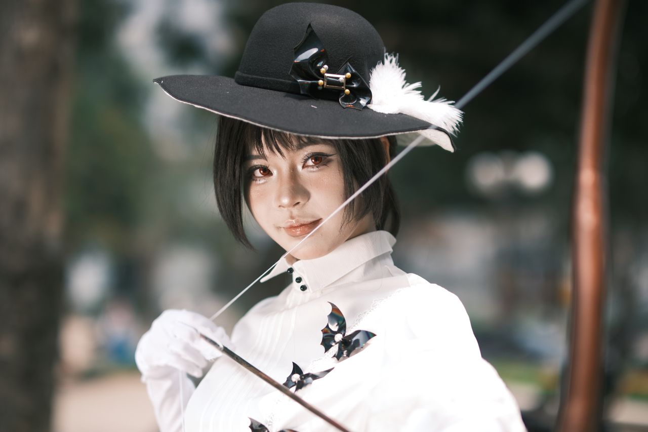 beautiful woman in elegant white outfit and black hat with a feather p