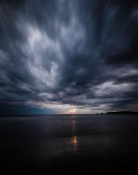 A mesmerizing view of a dark, overcast sky over the sea at twilight, capturing the beauty of stormy weather.