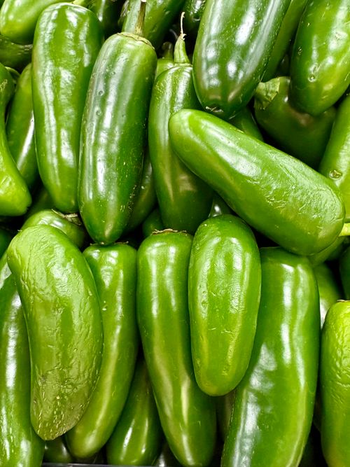 Free A vibrant display of fresh green jalapeño peppers, perfect for culinary use. Stock Photo