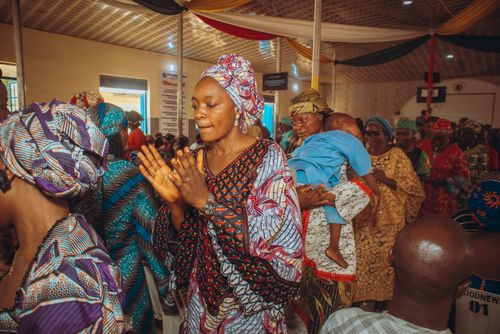 Free A lively scene of people in colorful traditional attire at an indoor ceremony. Stock Photo