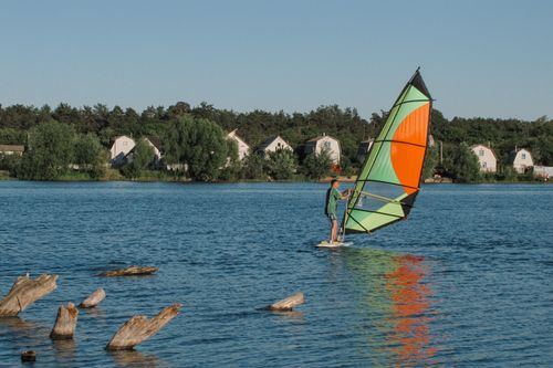 Free A person windsurfing on a serene lake in Chernihiv, Ukraine during summer. Stock Photo