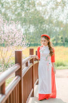 春天，一位美丽的年轻女子身着奥戴，漫步在风景优美的桥上