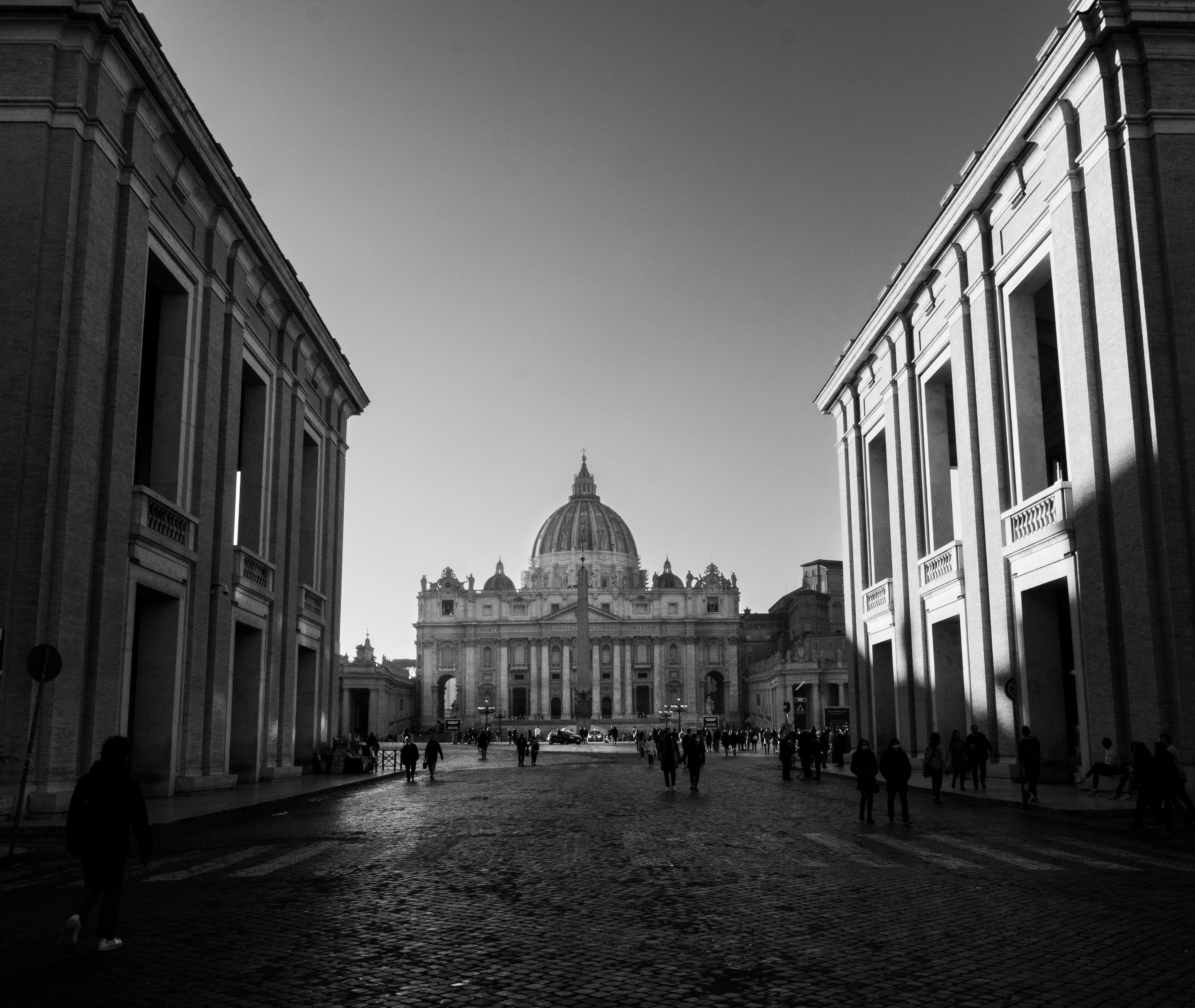 Majestic view of St. Peter's Basilica in Vatican City, capturing its iconic architecture and vibrant street life.