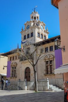 Charming historic building in IB, Spain with architectural details and clear blue sky.