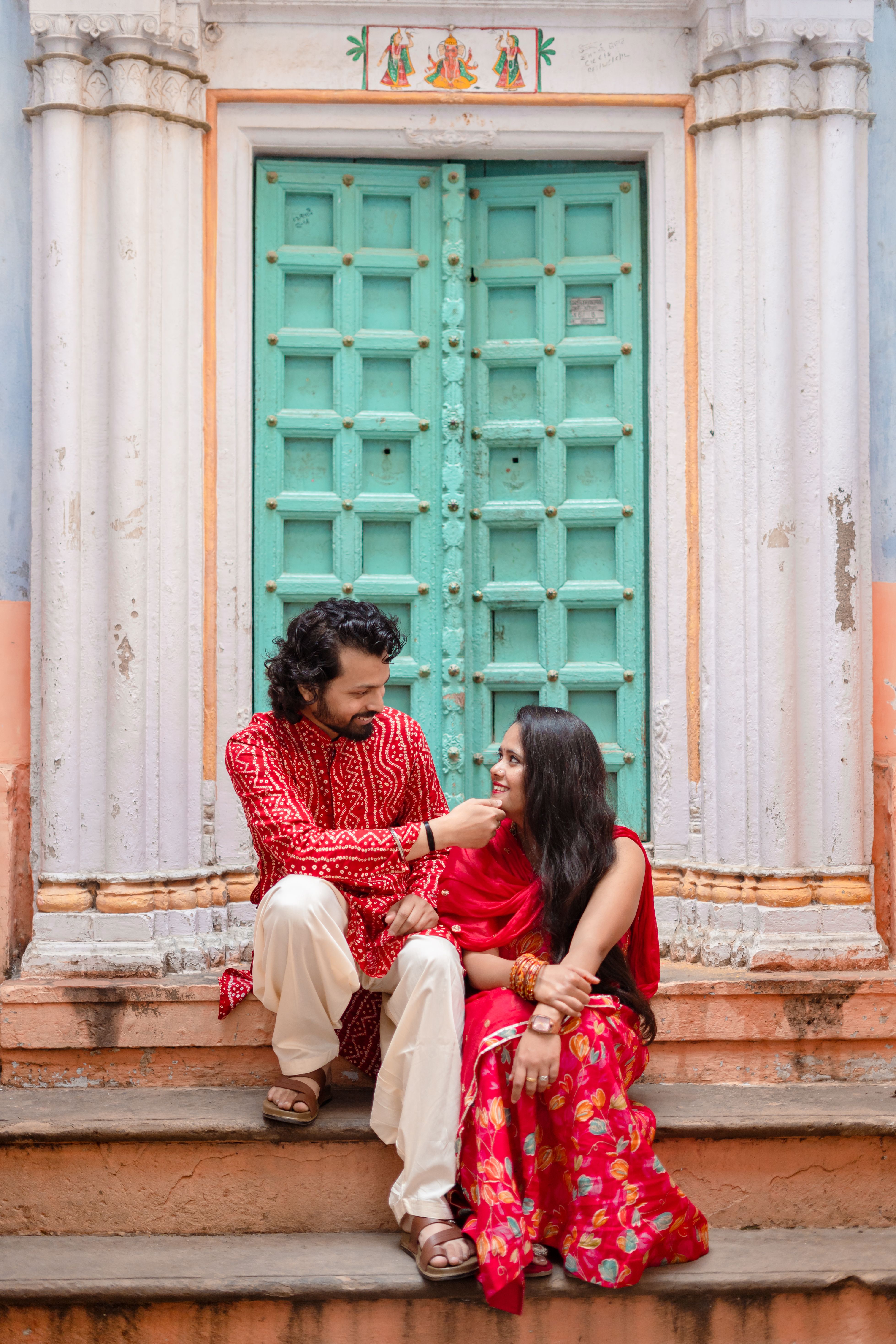 Couple in Traditional Attire by Historic Gateway · Free Stock Photo
