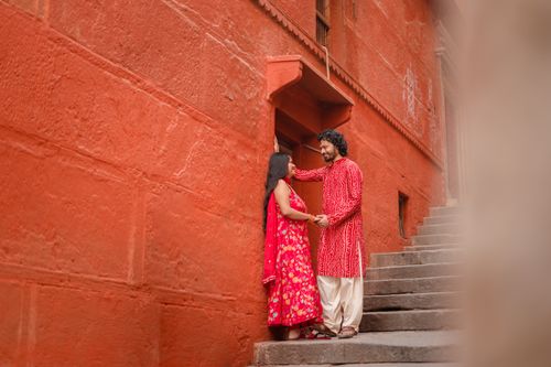 Free A couple embraces on a vibrant red street in Varanasi, symbolizing love and tradition. Stock Photo