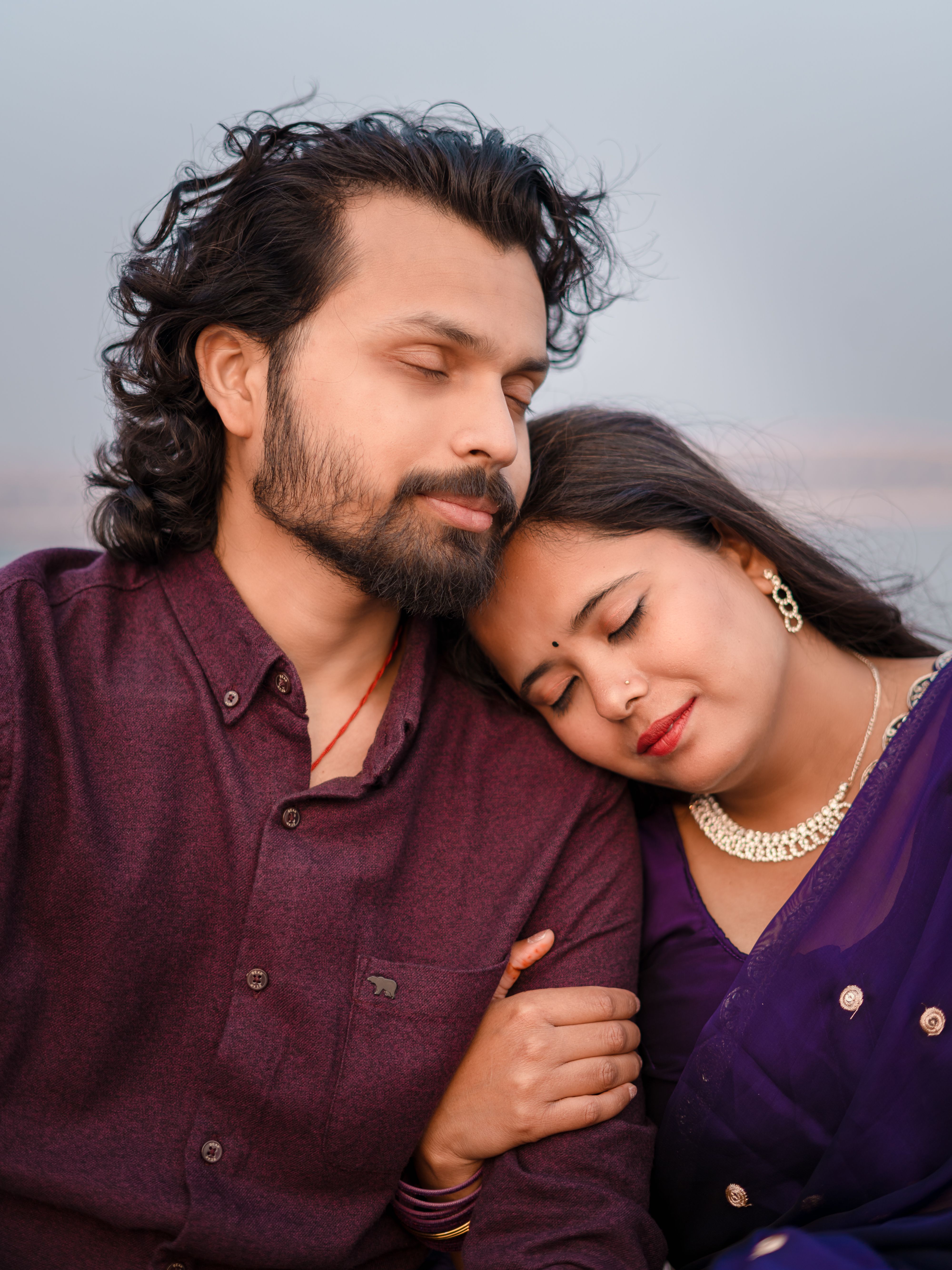 A loving couple shares an intimate moment at sunset in Varanasi, India, symbolizing love and connection.